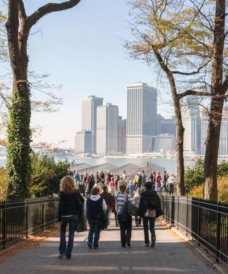 People walking along the Brooklyn Heights Promenade with views of the Lower Manhattan skyline