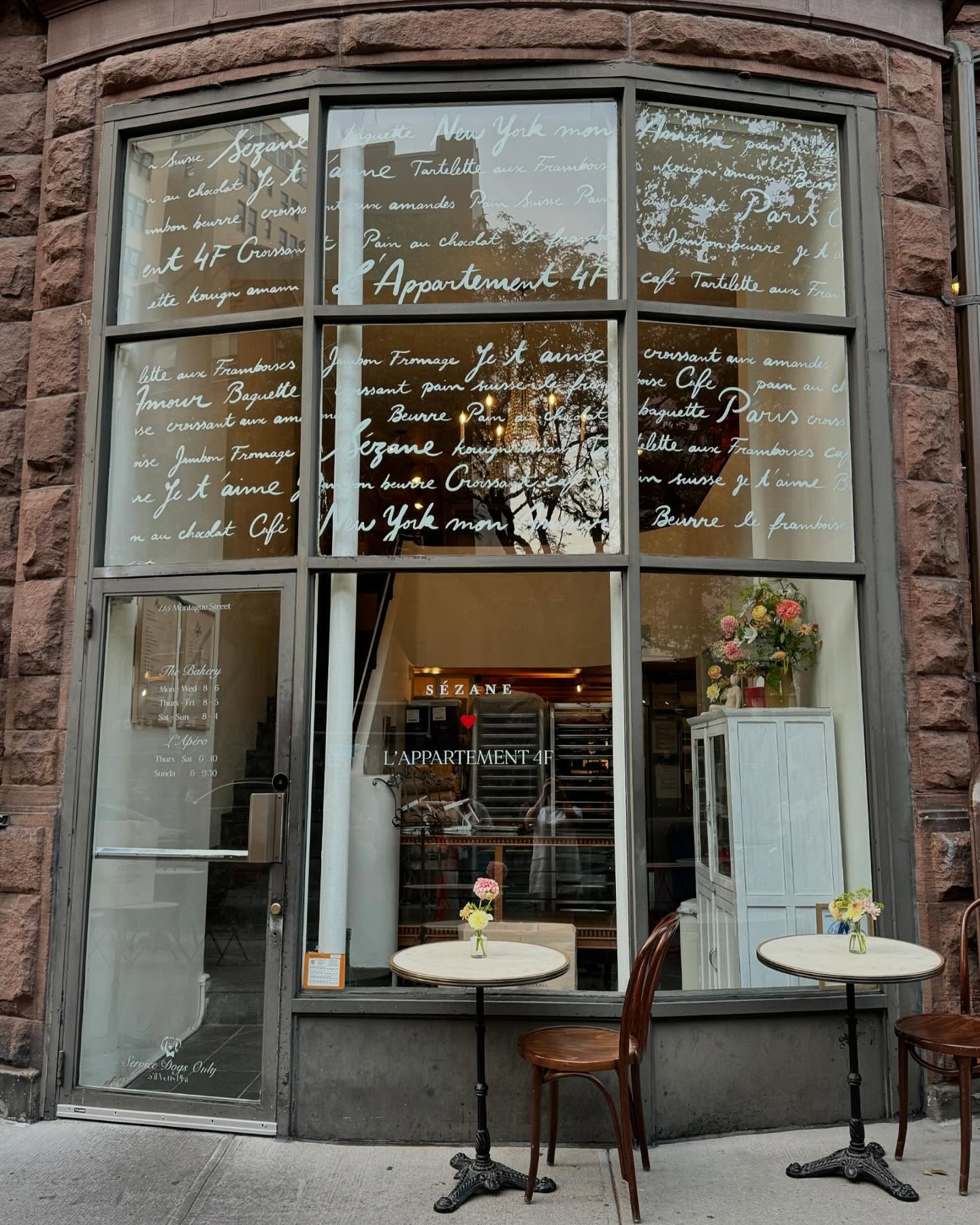 French-inspired café storefront with handwritten window lettering and outdoor seating in Brooklyn Heights